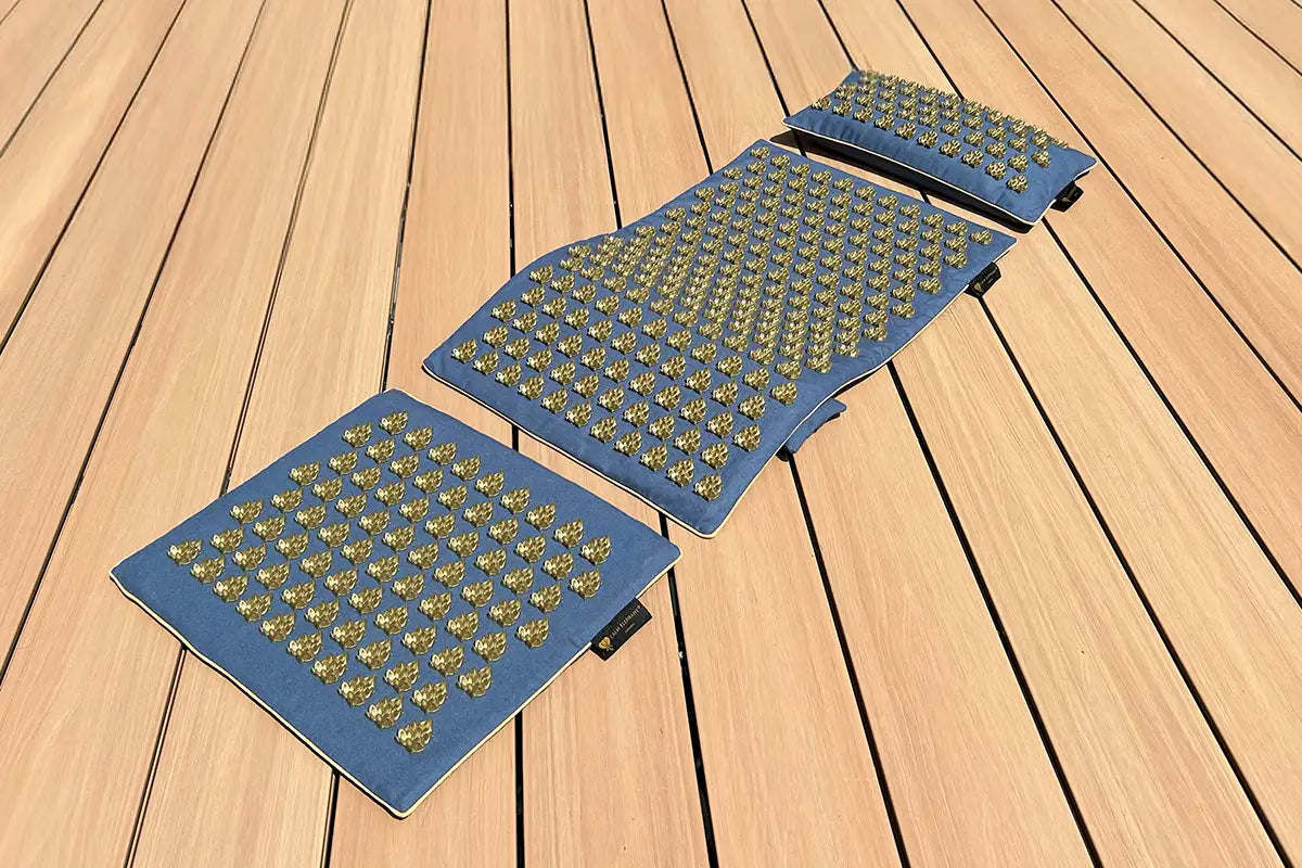 Eine Akupressurmatte liegt auf dem Boden einer Terrasse. Die Akupressurmatten-Set PUR ECO besteht aus drei Teilen und ist das Einsteigermodel von CALM ELEPHANT